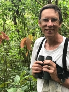 Portrait of Philip Stoddard ’79 holding binoculars. 